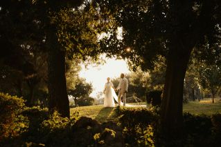 A romantic wedding couple enjoys a sunset moment in Antalya's lush garden setting.